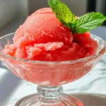 Refreshing Watermelon Sorbet in Glass Bowl with Mint Garnish on Marble Countertop
