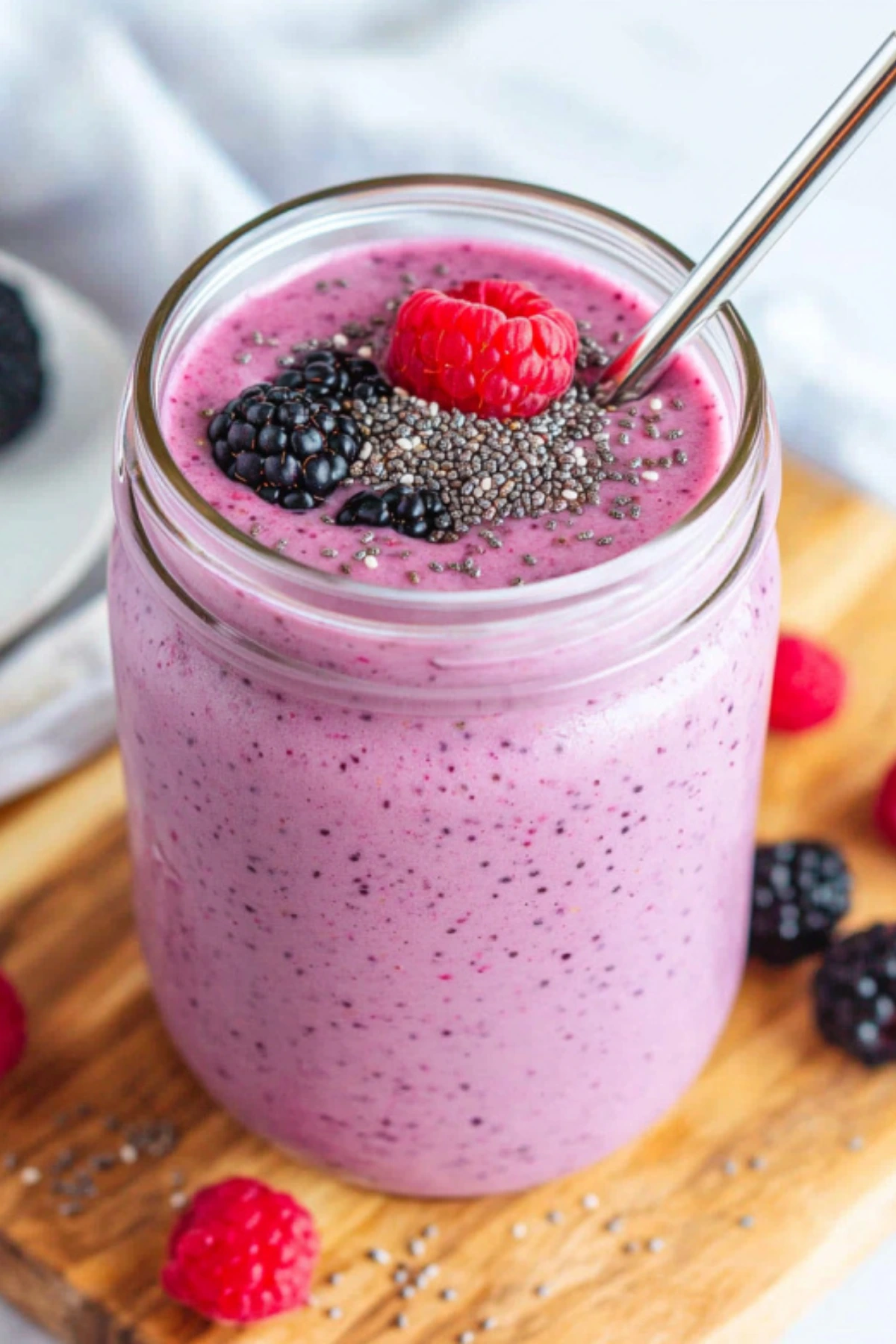 Fiber rich smoothies with chia seeds and berries in glass jar on wooden board - purple smoothie recipe for digestive health