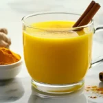 A warm cup of Natural Mounjaro drink featuring turmeric, cinnamon sticks, and a sprinkle of ginger powder, perfect for health and wellness.