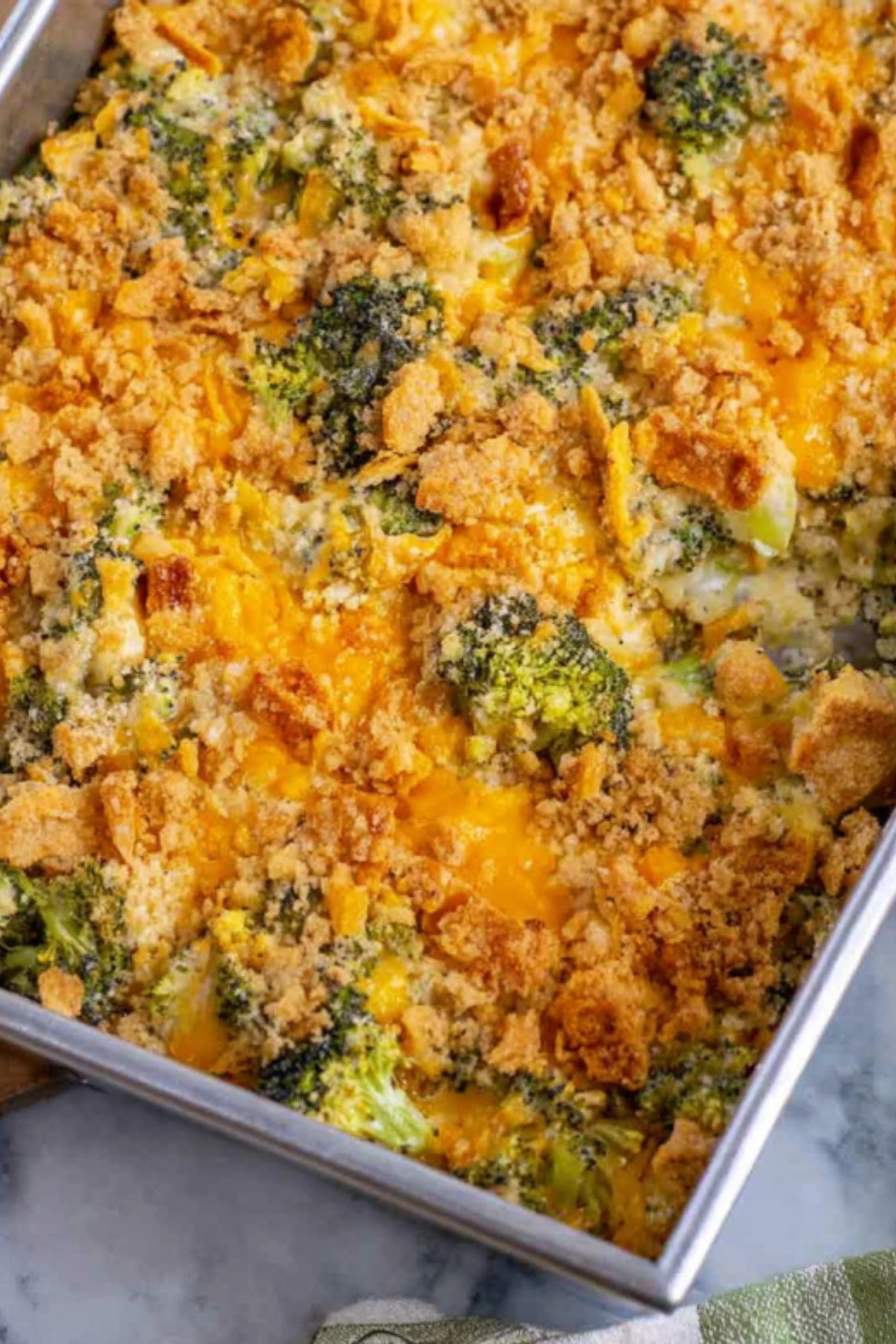 Golden baked broccoli casserole with melted cheddar cheese and crispy cracker topping in rectangular baking dish