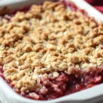 Strawberry Rhubarb Crumble with a golden, oat crumble topping in a baking dish