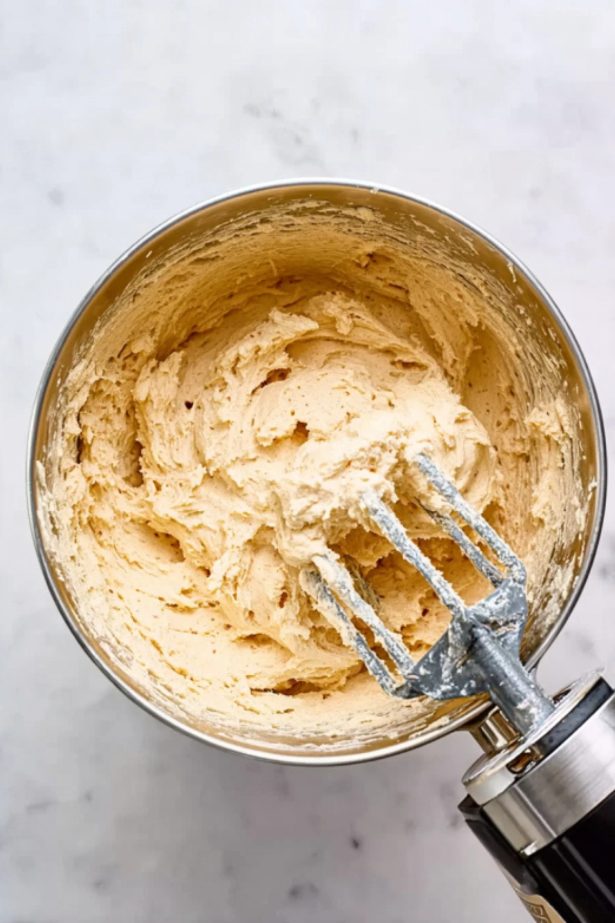 Perfectly mixed white chocolate macadamia nut cookie dough with electric hand mixer beaters
