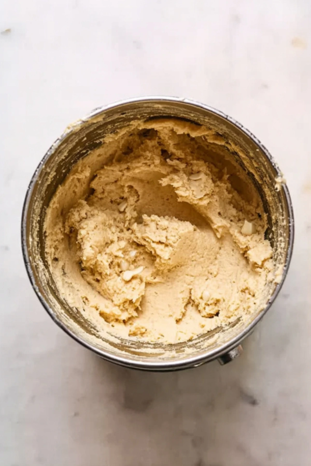 Creamy cookie dough in mixing bowl for white chocolate macadamia nut cookies recipe