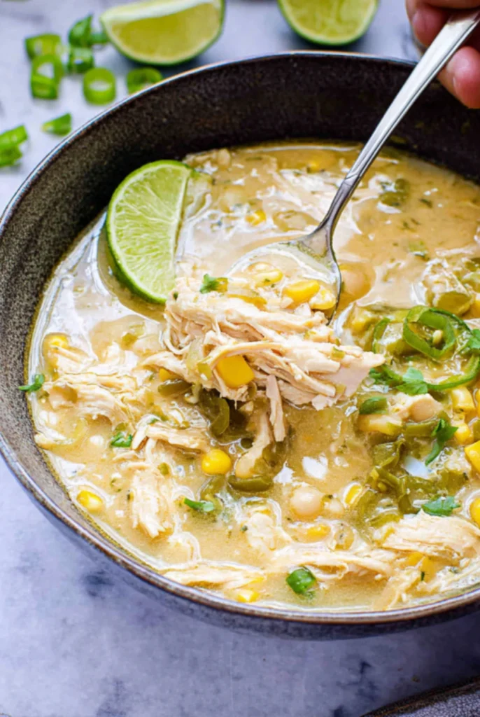 Bowl of White Chicken Chili with Green Chiles topped with lime and fresh jalapeños