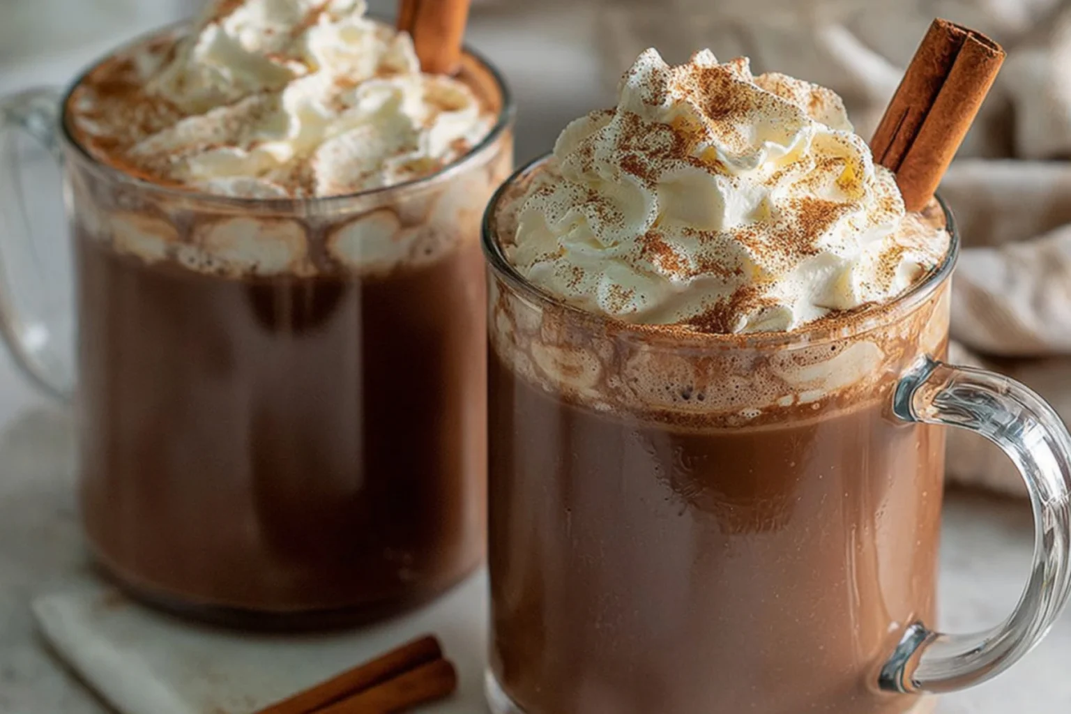Creamy Pumpkin Spice Hot Chocolate topped with whipped cream, cinnamon, and a cinnamon stick, perfect for fall.