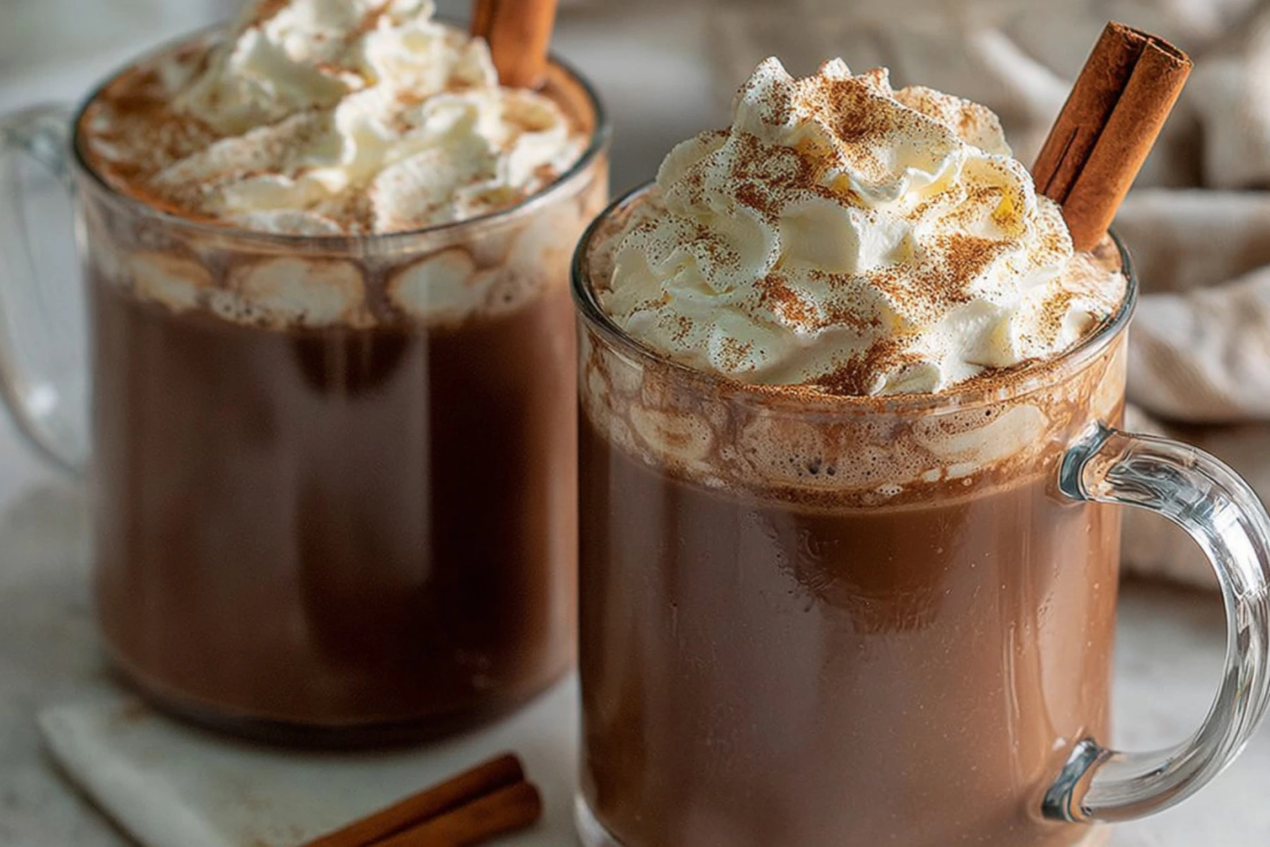 Creamy Pumpkin Spice Hot Chocolate topped with whipped cream, cinnamon, and a cinnamon stick, perfect for fall.