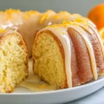 Orange Velvet Layer Cake with creamy orange glaze and zest on top