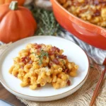 Pumpkin Mac and Cheese with Bacon served on a white plate with crispy bacon and fresh thyme garnish in a festive fall setting