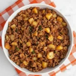 Ground turkey with potatoes in a white bowl on an orange checkered napkin, an easy skillet dinner perfect for busy weeknights.