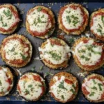 Healthy Eggplant Parmesan Bake with crispy roasted eggplant slices topped with marinara, melted mozzarella, and fresh basil on a baking tray.