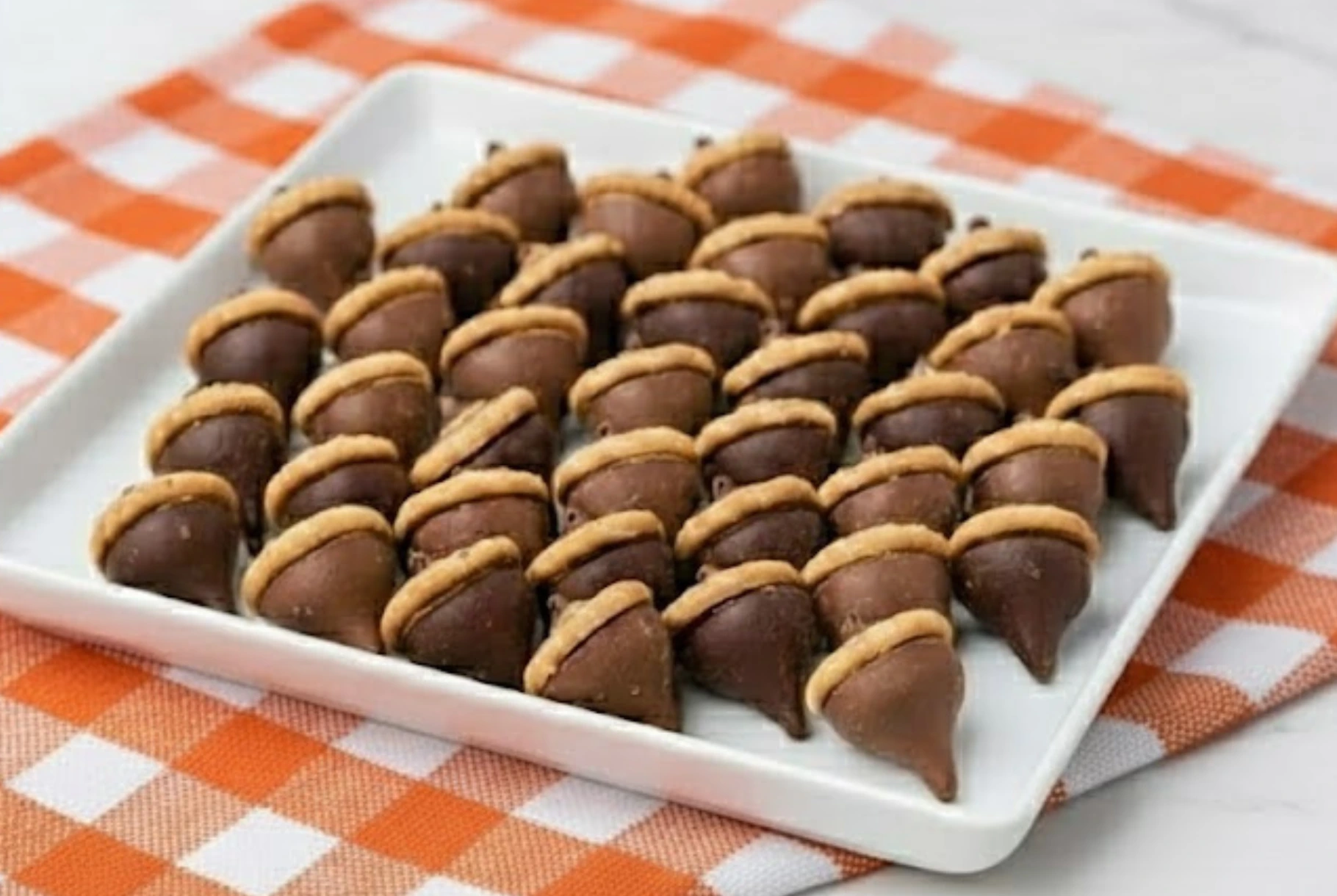 Homemade Kisses Acorn Treats made with Hershey’s Kisses and mini cookies on a fall-themed table