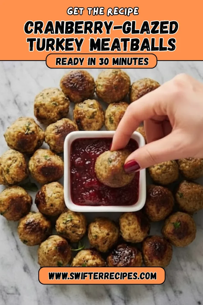 Cranberry glazed turkey meatballs with cranberry sauce served in a small bowl, surrounded by meatballs on marble, labeled ready in 30 minutes.