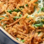 Green bean casserole topped with crispy fried onions in a baking dish