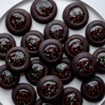 Plate of chocolate holiday cookies with glossy centers and sprinkles