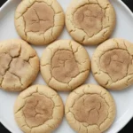 Chewy cinnamon sugar cookies on a white plate showing soft centers and cracked edges