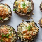 Best Vegetarian Stuffed Mushrooms with golden melted cheese and herb breadcrumb filling baked to perfection on a marble surface