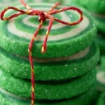 Green Christmas Pinwheel Cookies stacked and tied with red string for a festive holiday treat.