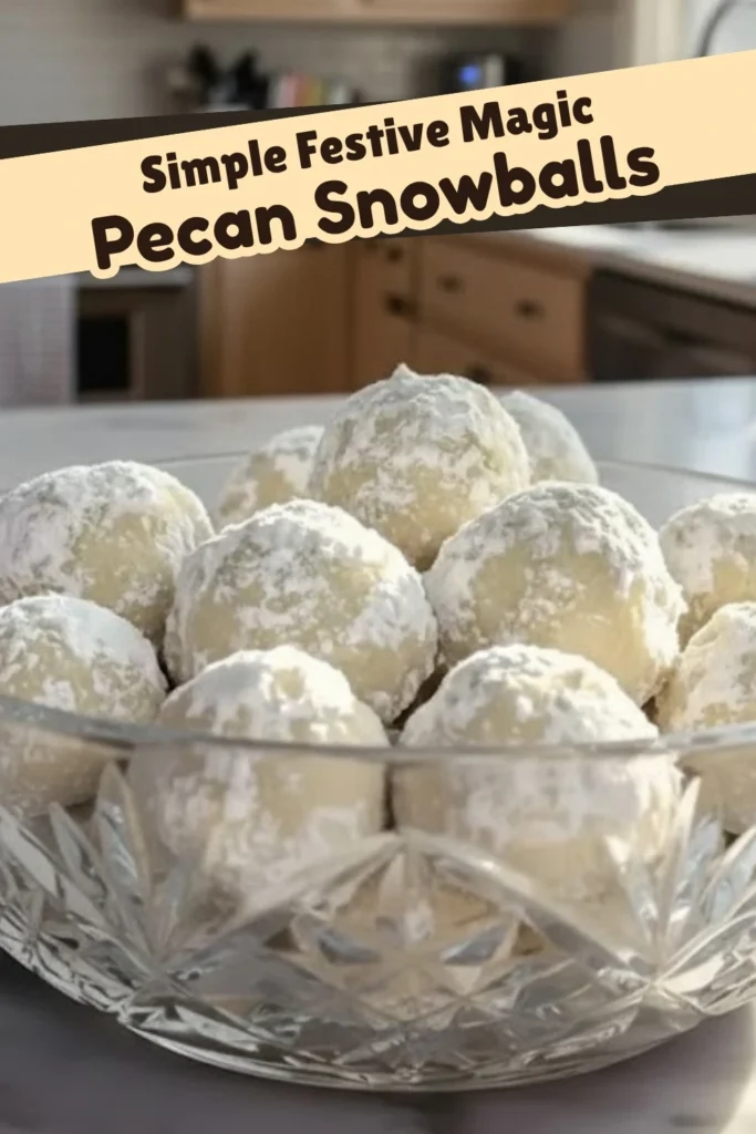 Pecan snowball cookies coated in powdered sugar displayed in a glass bowl with festive kitchen background