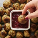 Cranberry glazed turkey meatballs served with tangy cranberry dipping sauce on a marble surface, perfect for holidays or family dinners.