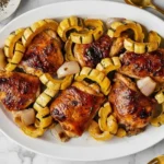 Miso-Honey Chicken with Delicata Squash roasted to perfection with caramelized shallots and honey glaze on a white platter.