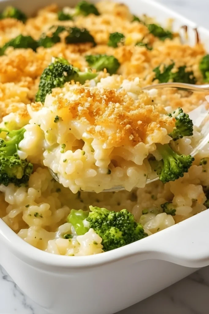 Cheesy broccoli rice casserole with creamy sauce and crispy breadcrumb topping served hot in a white baking dish.