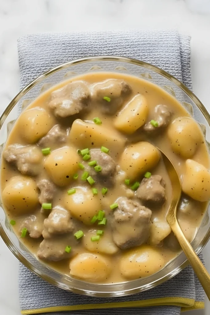 Creamy steak and potato soup in a bowl with tender beef chunks, soft golden potatoes, and chives on top