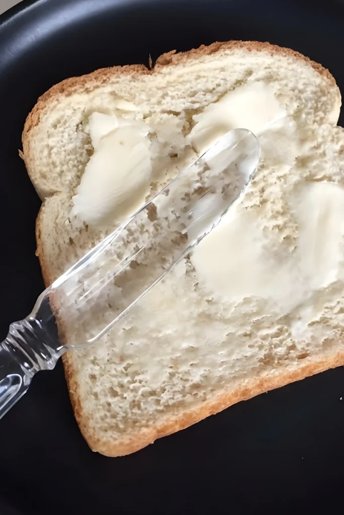 Spreading Butter on Bread for Apple Cranberry Grilled Cheese Sandwich