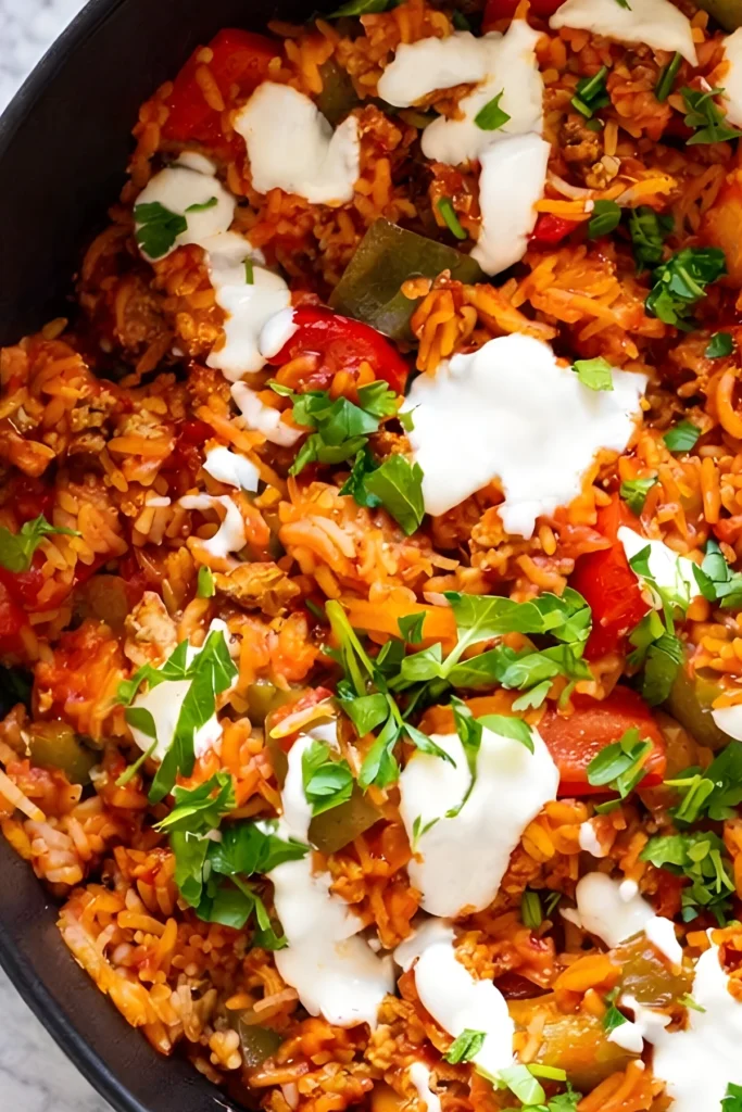 Deconstructed Stuffed Peppers Skillet with ground turkey rice bell peppers marinara sauce topped with sour cream and fresh parsley
