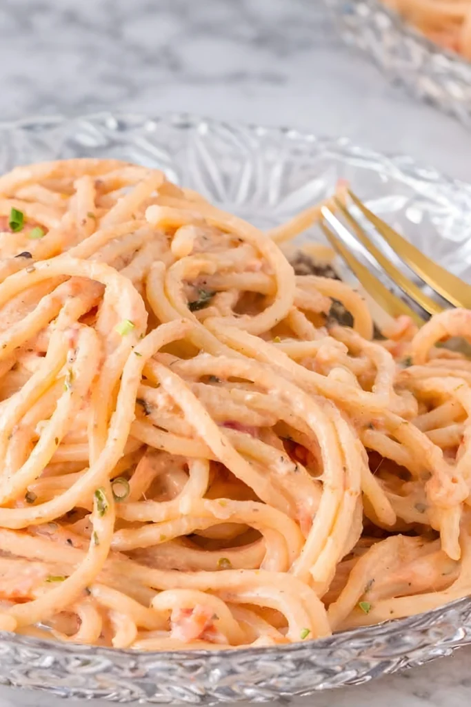 Creamy Italian pink sauce pasta served on a clear glass plate with a gold fork