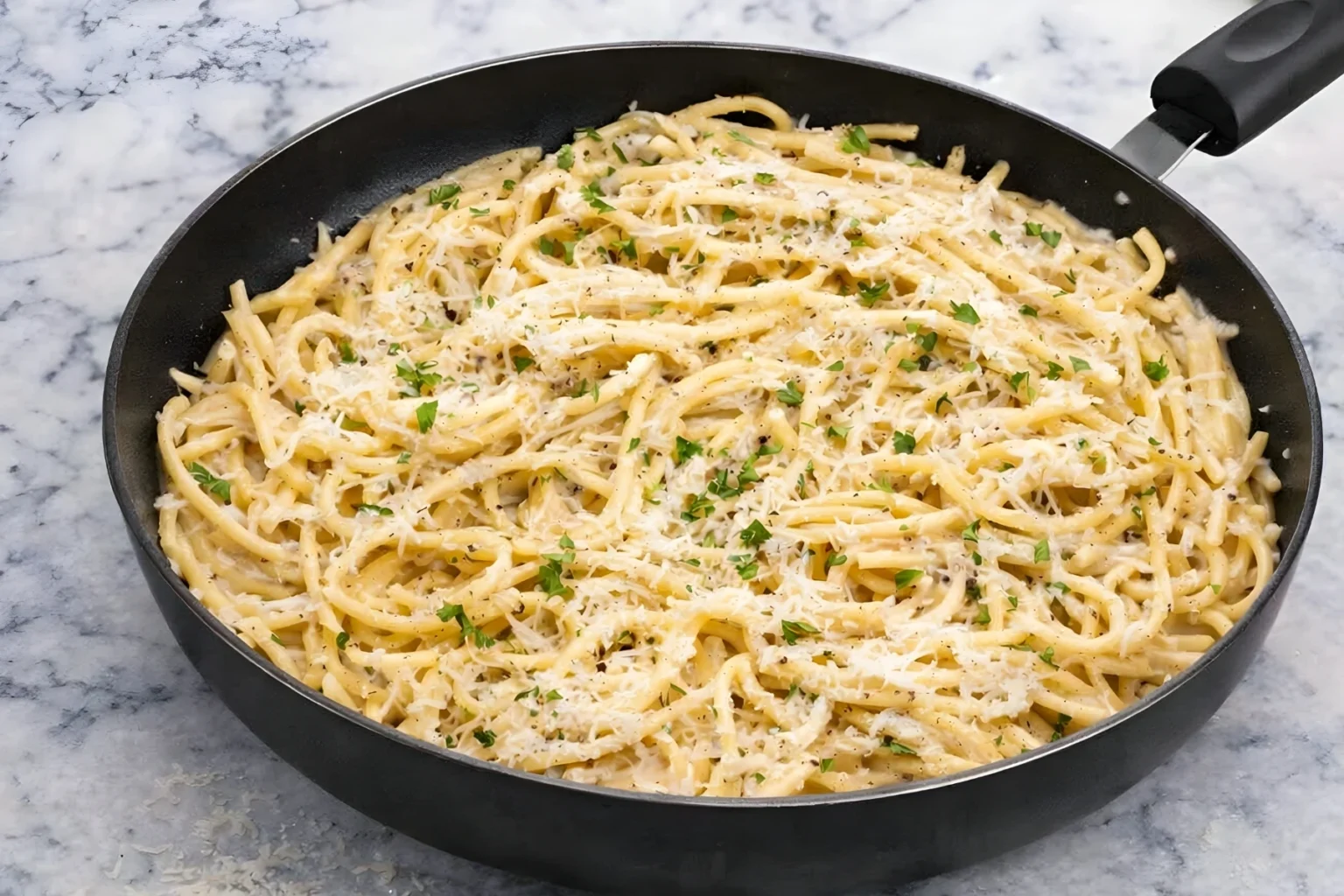 Bucatini Cacio e Pepe served in a skillet with creamy cheese sauce and cracked black pepper