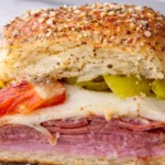 Hot Italian sub slider with layers of ham salami pepperoni melted provolone and peppers on a toasted roll