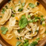 Bowl of Thai Chicken Curry Soup with rice noodles, shredded chicken, cilantro, and green onions