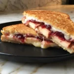 Apple Cranberry Grilled Cheese Sandwich with melted Swiss cheese, fresh apples, and cranberry sauce on golden toasted bread