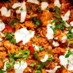 Deconstructed Stuffed Peppers Skillet with ground turkey rice and bell peppers topped with sour cream and fresh parsley in a skillet