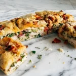Focaccia turkey sandwich sliced into portions with pesto mayo turkey tomato and greens on toasted sun dried tomato focaccia