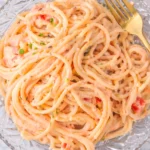 Creamy Italian pink sauce pasta with spaghetti in a tomato cream sauce on a glass plate