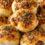 Garlic parmesan cheeseburger bombs baked golden with buttery garlic topping and melted cheese inside, served as bite sized stuffed biscuits