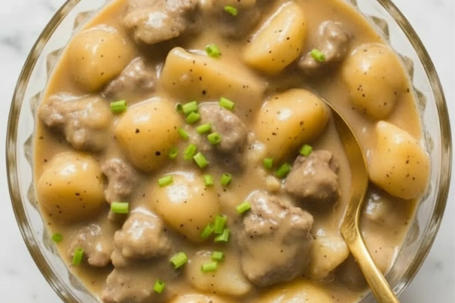 Creamy steak and potato soup in a bowl with tender beef chunks and golden potatoes topped with fresh chives