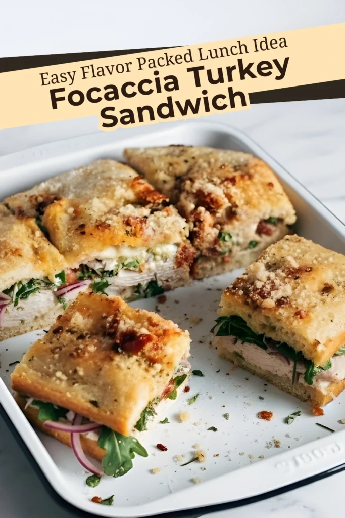 Focaccia turkey sandwich cut into squares with pesto mayo turkey greens and red onion on toasted focaccia with text overlay
