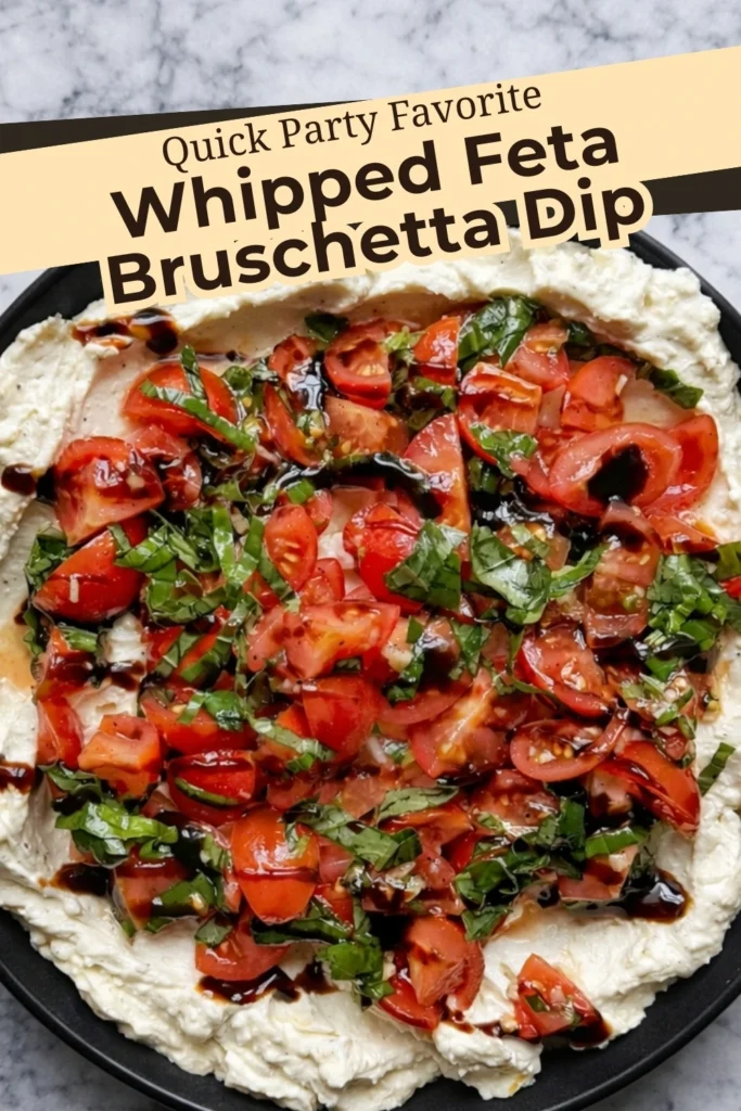 Whipped feta bruschetta dip topped with fresh cherry tomatoes basil and balsamic glaze on a black plate