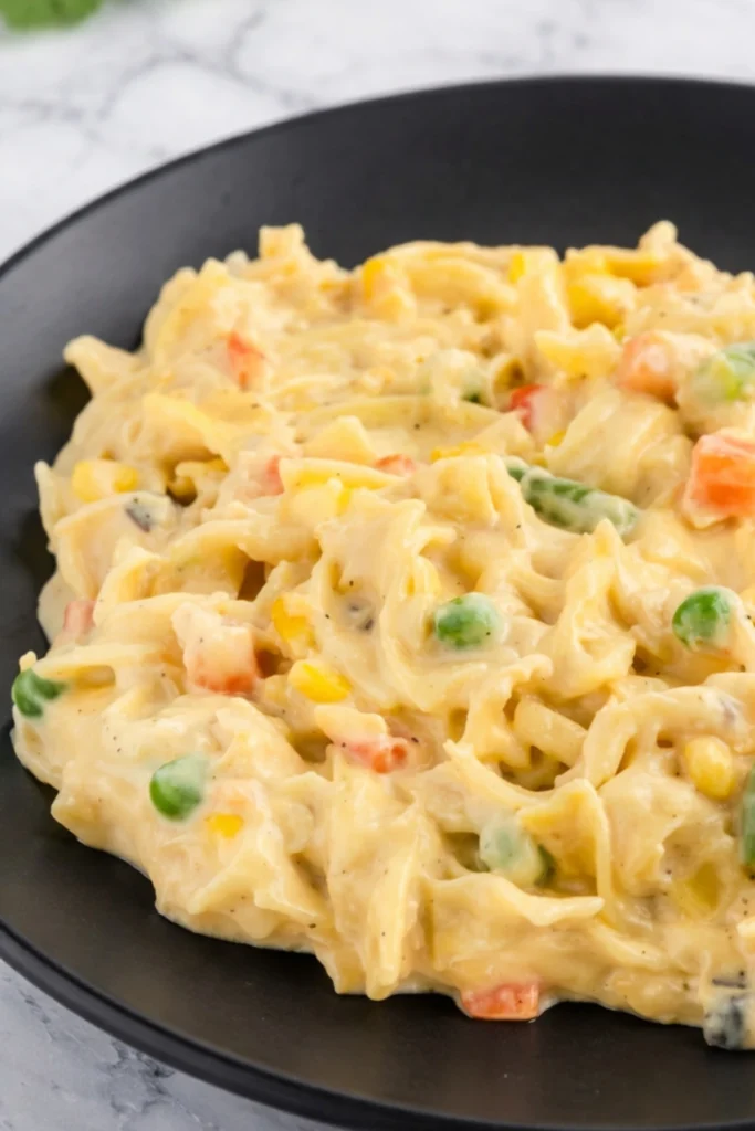 Creamy chicken pot pie casserole with noodles peas carrots and corn