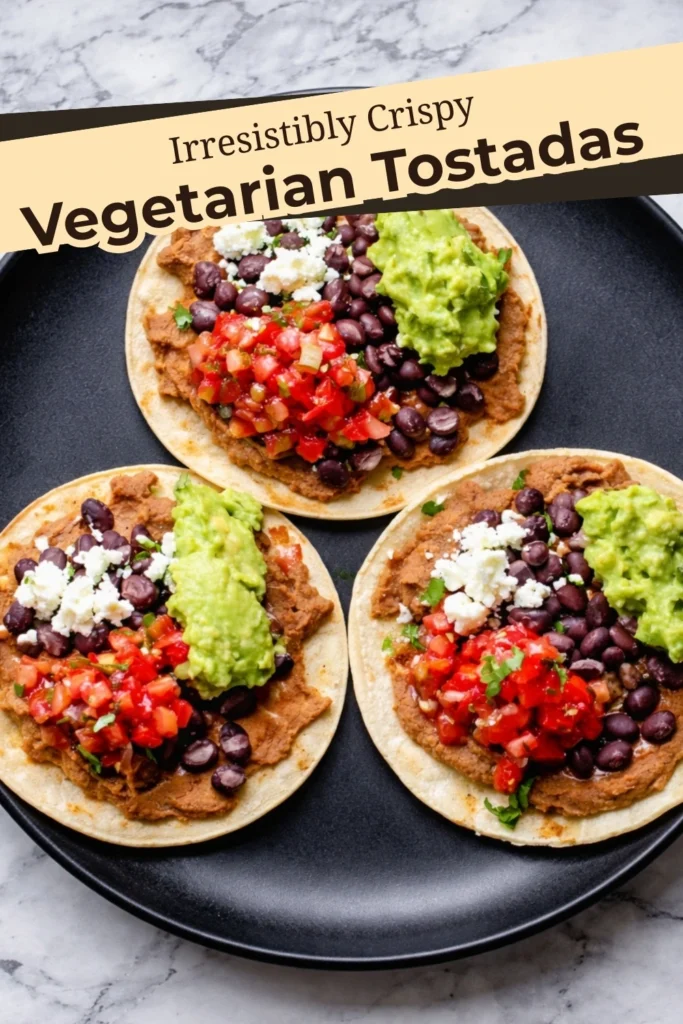 Three crispy vegetarian tostadas with refried beans, black beans, guacamole, pico de gallo, and cheese on a black plate