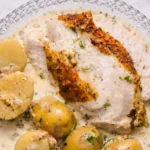 Creamy lemon and herb pot roasted chicken served with baby potatoes in a rich creamy sauce