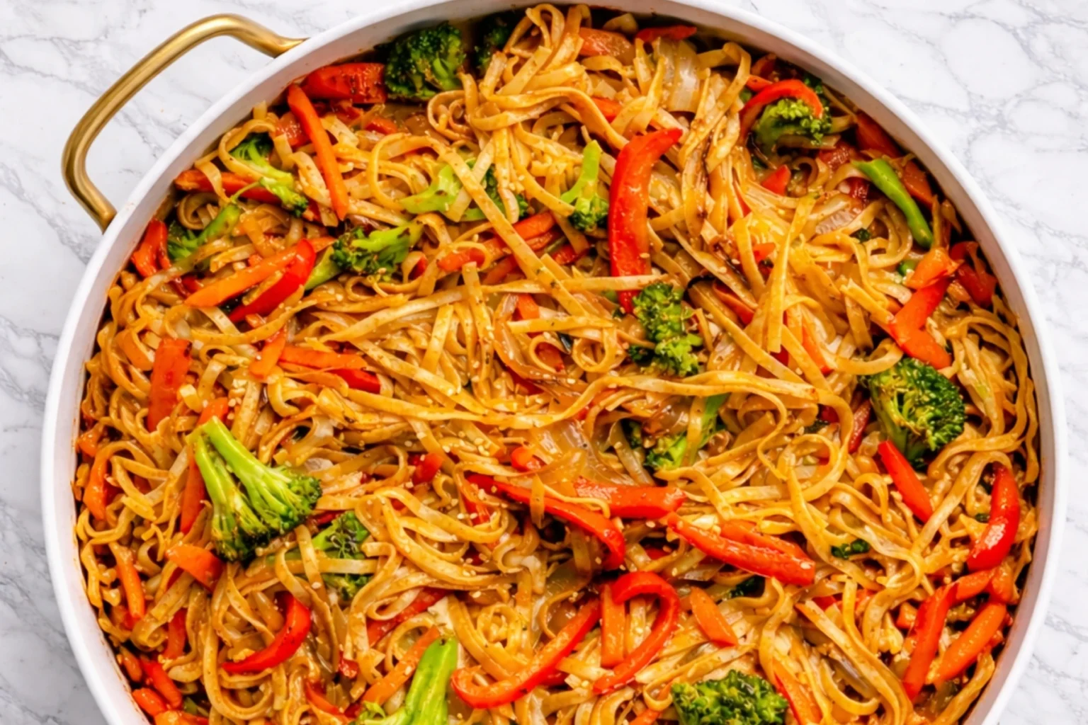 Veggie Lo Mein noodles with broccoli, bell peppers, and carrots in a white skillet
