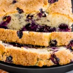 Freshly sliced moist blueberry loaf with golden crust and juicy berries
