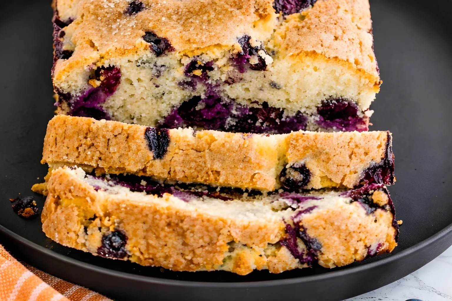 Freshly sliced moist blueberry loaf with golden crust and juicy berries