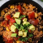 Instant Pot Mexican Quinoa topped with avocado, black beans, corn, salsa, and fresh cilantro in a black bowl