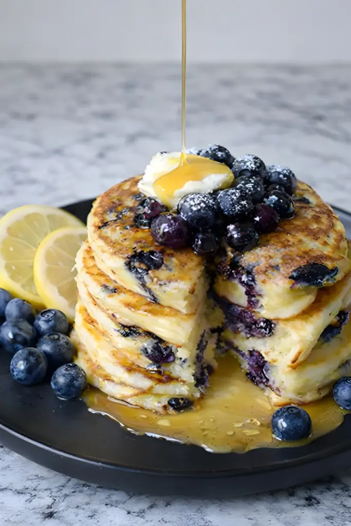 Lemon blueberry sourdough pancakes topped with blueberries and maple syrup