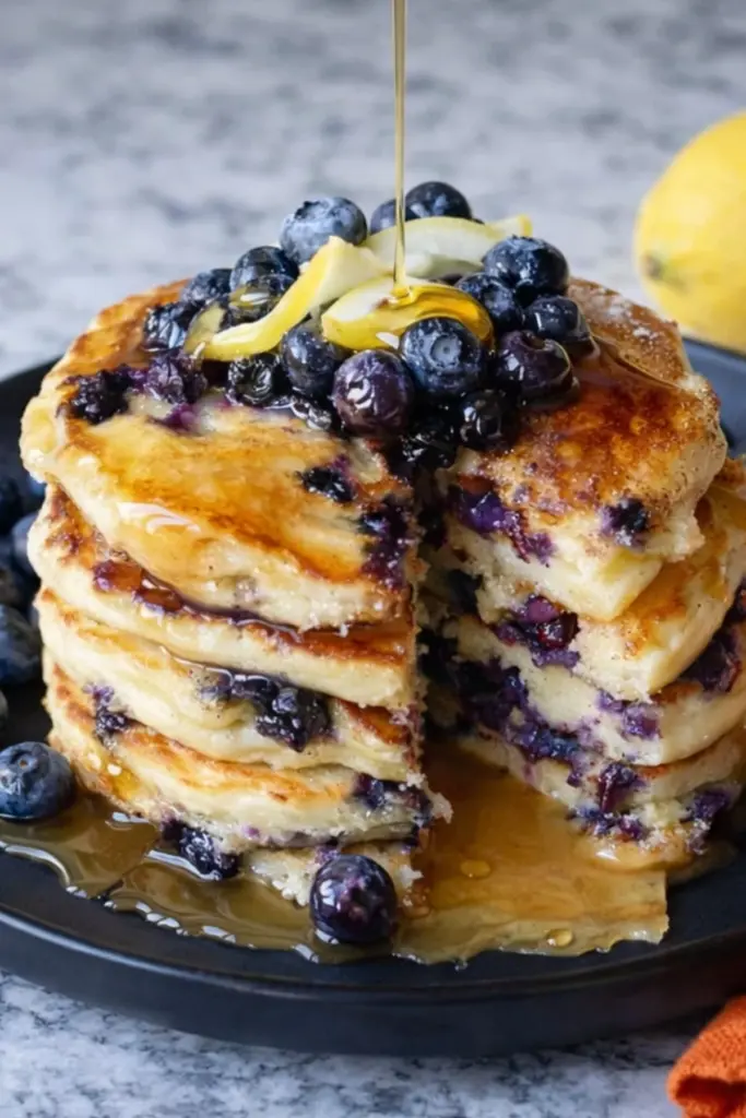 Lemon blueberry sourdough pancakes stacked with maple syrup and fresh blueberries