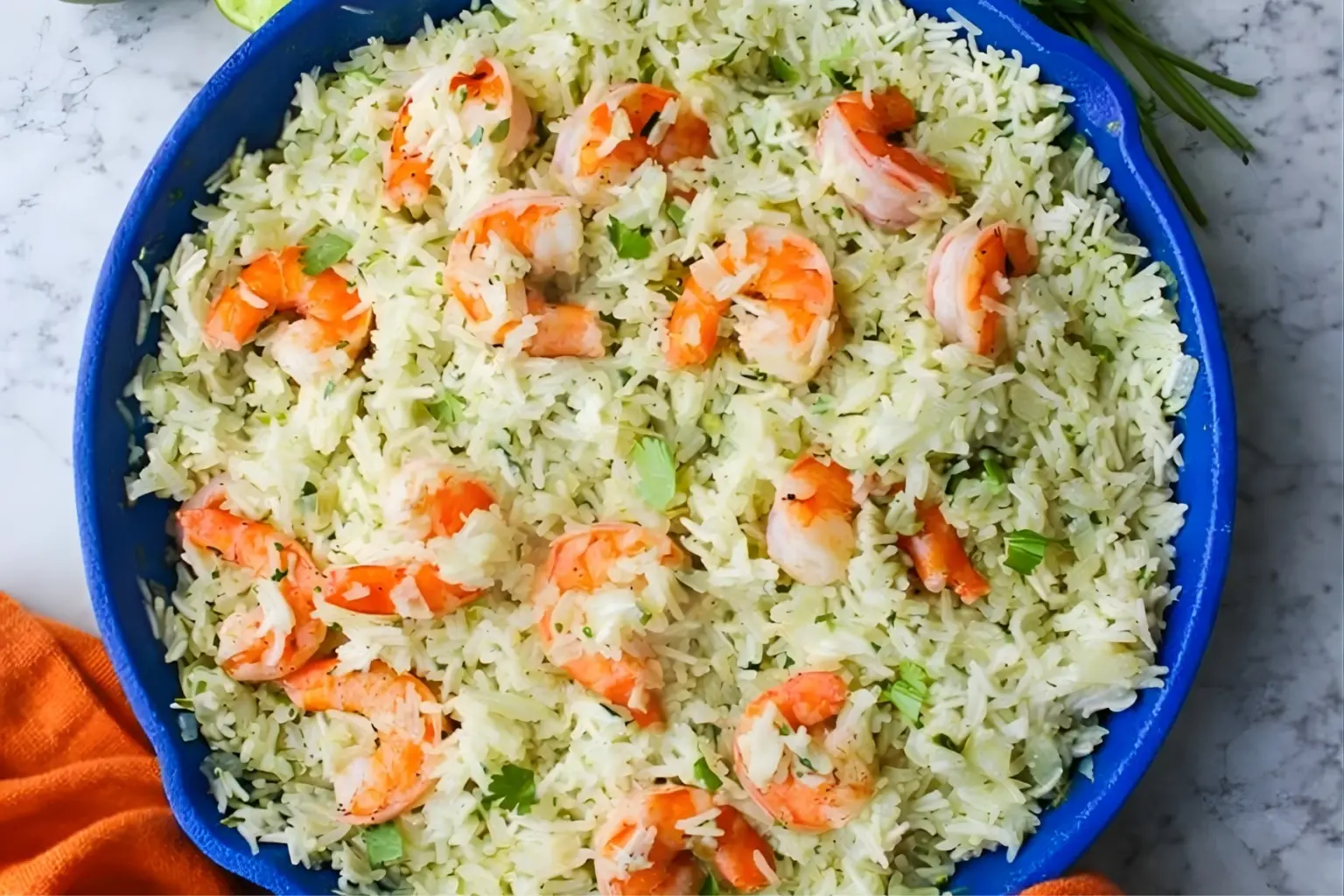 Cilantro Lime Shrimp & Rice in a blue skillet with fluffy white rice, pink shrimp, fresh cilantro, and lime on a marble surface